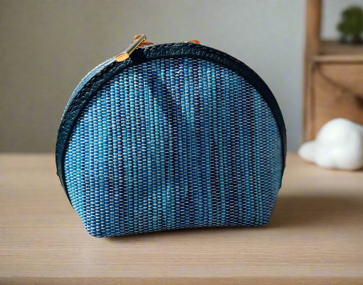 Blue textured pouch with a black zipper on a wooden surface