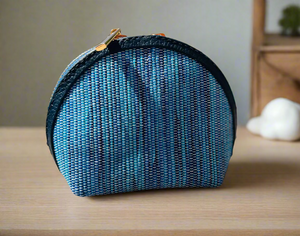 Blue textured pouch with a black zipper on a wooden surface